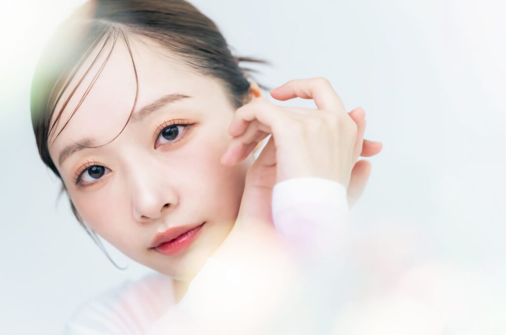 Eine asiatische Frau mit einem natürlichen, sanften Beauty-Look und perfekt geschwungenen Wimpern, passend zum Korean Lash Lift Trend.